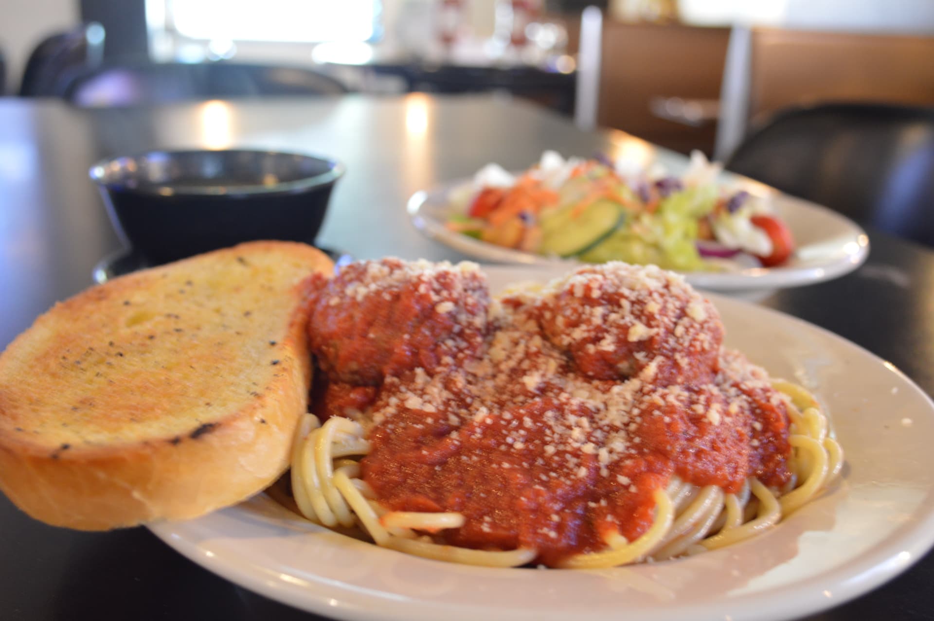 Spaghetti and meatballs with marinara, garlic bread, and a side salad