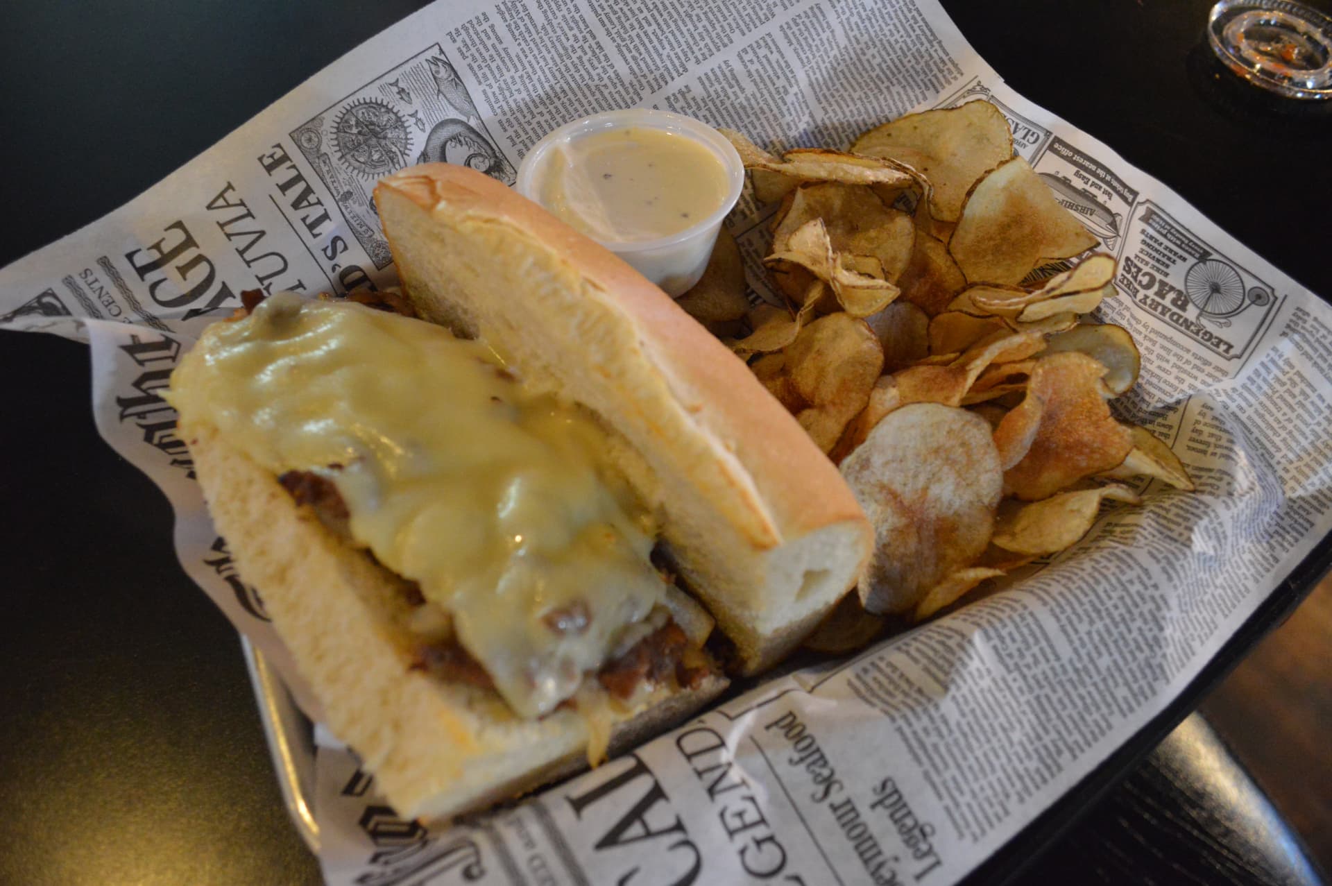 Classic Philly cheesesteak with melted cheese served with house-made potato chips